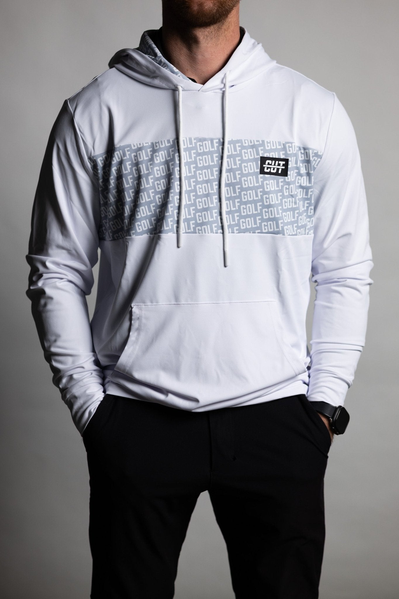 Man wearing GOLF Whiteout Athletic Hoodie with gray patterned chest panel and front pocket, styled with black pants