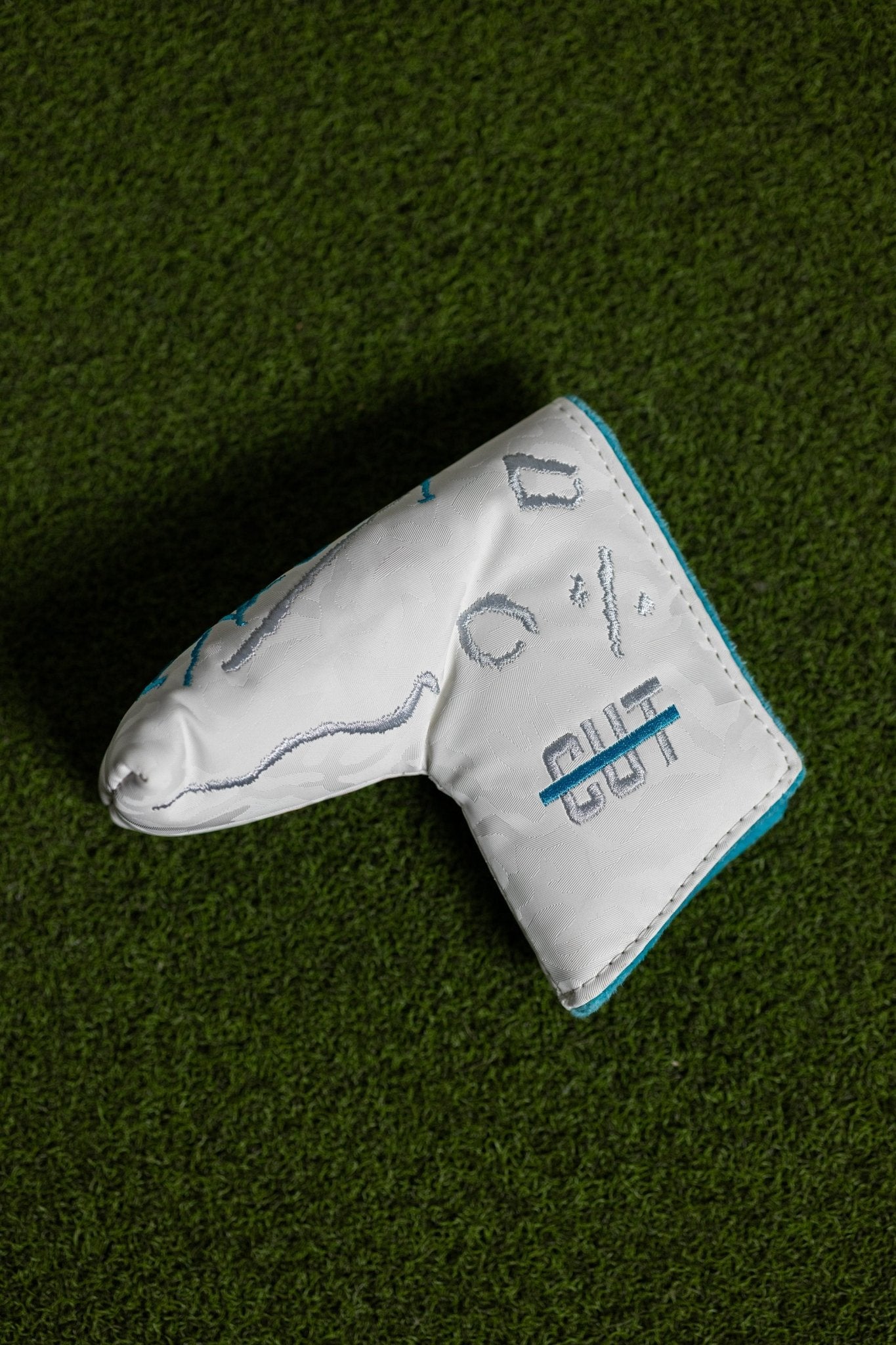 No Bogeys White Blade Cover with embroidered golf design and blue trim on textured green turf background