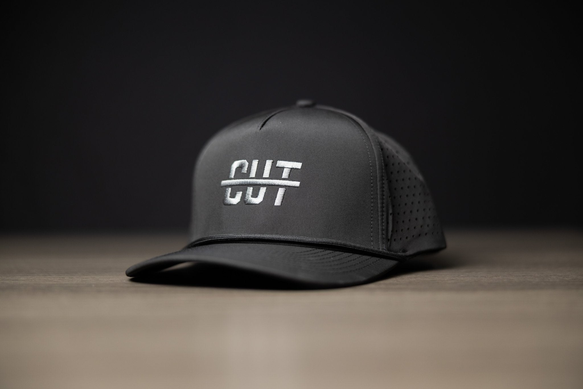 Blackout Cutline Hat in black with perforated mesh back and white logo embroidery for stylish golf gear look