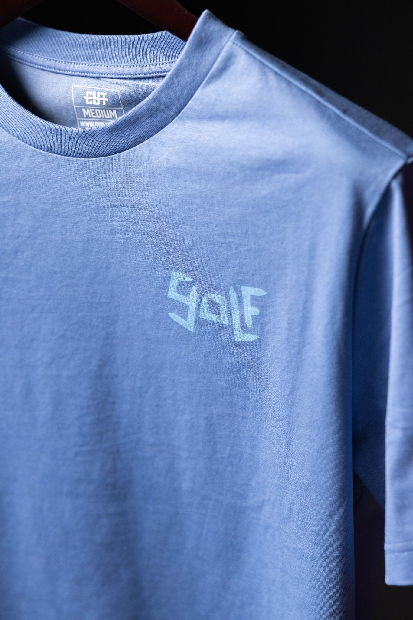 Light blue Play More Golf T-Shirt with geometric golf text design on chest in soft cotton fabric