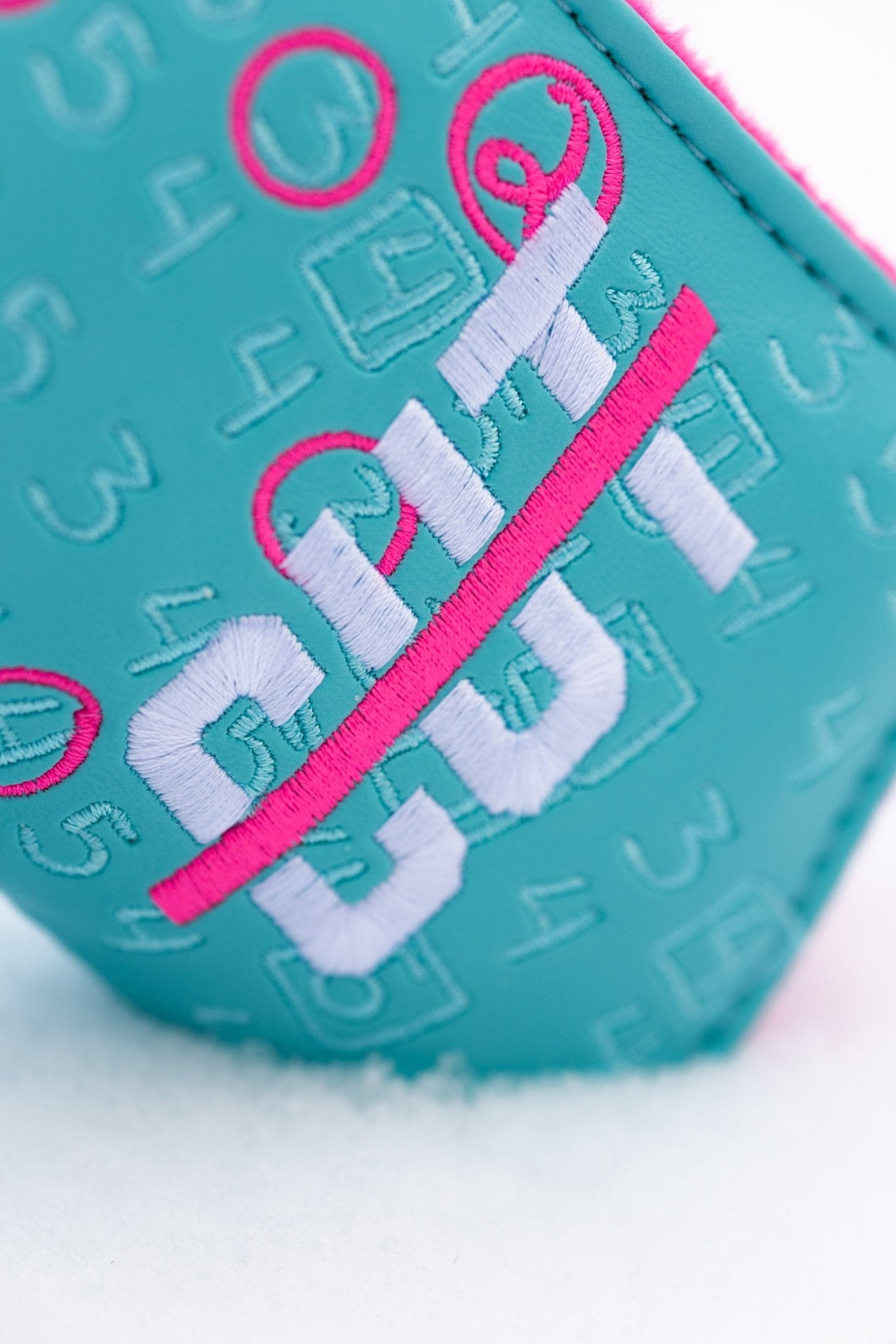 Scorecard Teal Blade golf headcover with embroidered Cutline Golf Goods logo on textured teal material in snow.