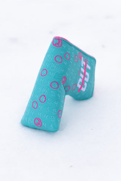 Scorecard Teal Blade golf putter headcover with teal color and pink accents on snow background
