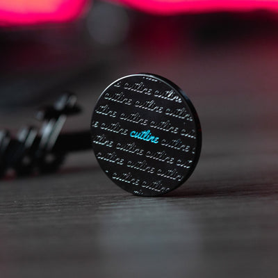 Cut "LINE" Alignment Ball Marker showing black design with repeated script and blue highlight on a wood surface background.