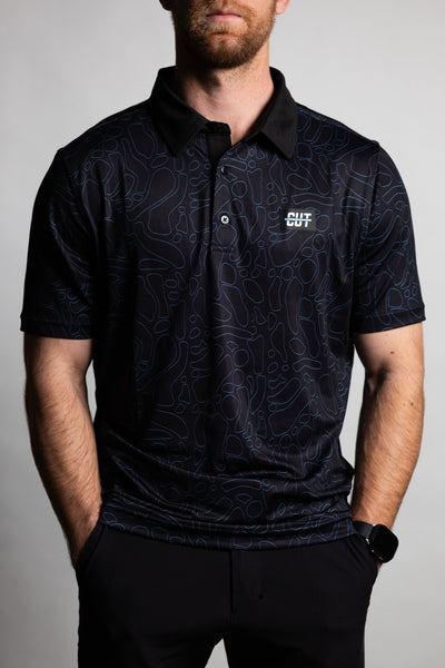 Man wearing a black Midnight Teal Topo Polo with subtle topographic patterns and a small Cutline Golf Goods logo on chest