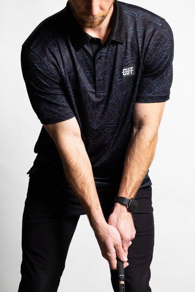 Man wearing a Midnight Teal Topo Polo golf shirt with topographic pattern preparing to swing golf club