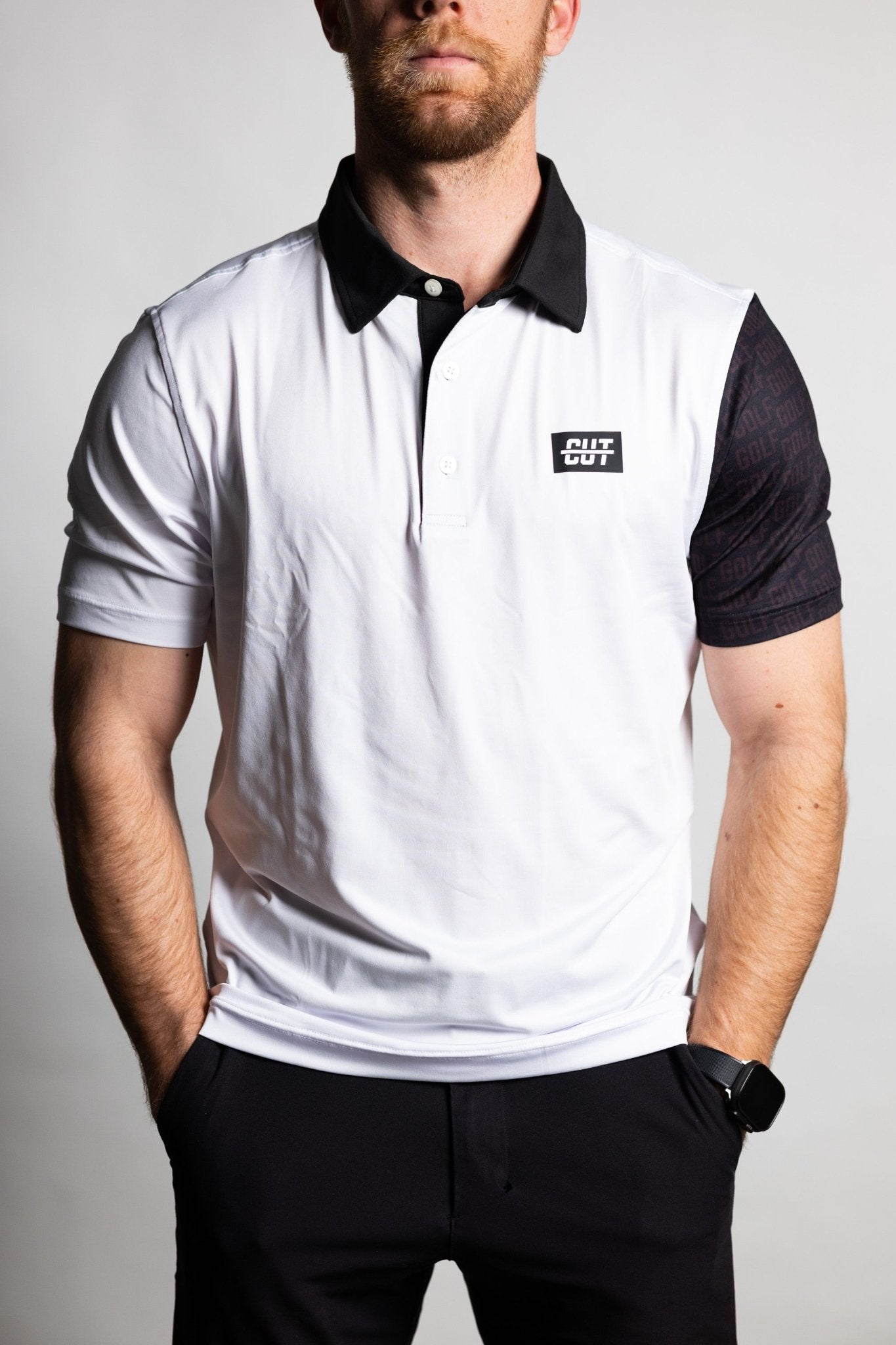 Man wearing a GOLF Arm Whiteout Polo with a white body, black collar, and contrasting black sleeve with subtle pattern.