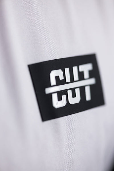 Close-up of a black and white logo patch on the GOLF Arm Whiteout Polo golf apparel fabric.
