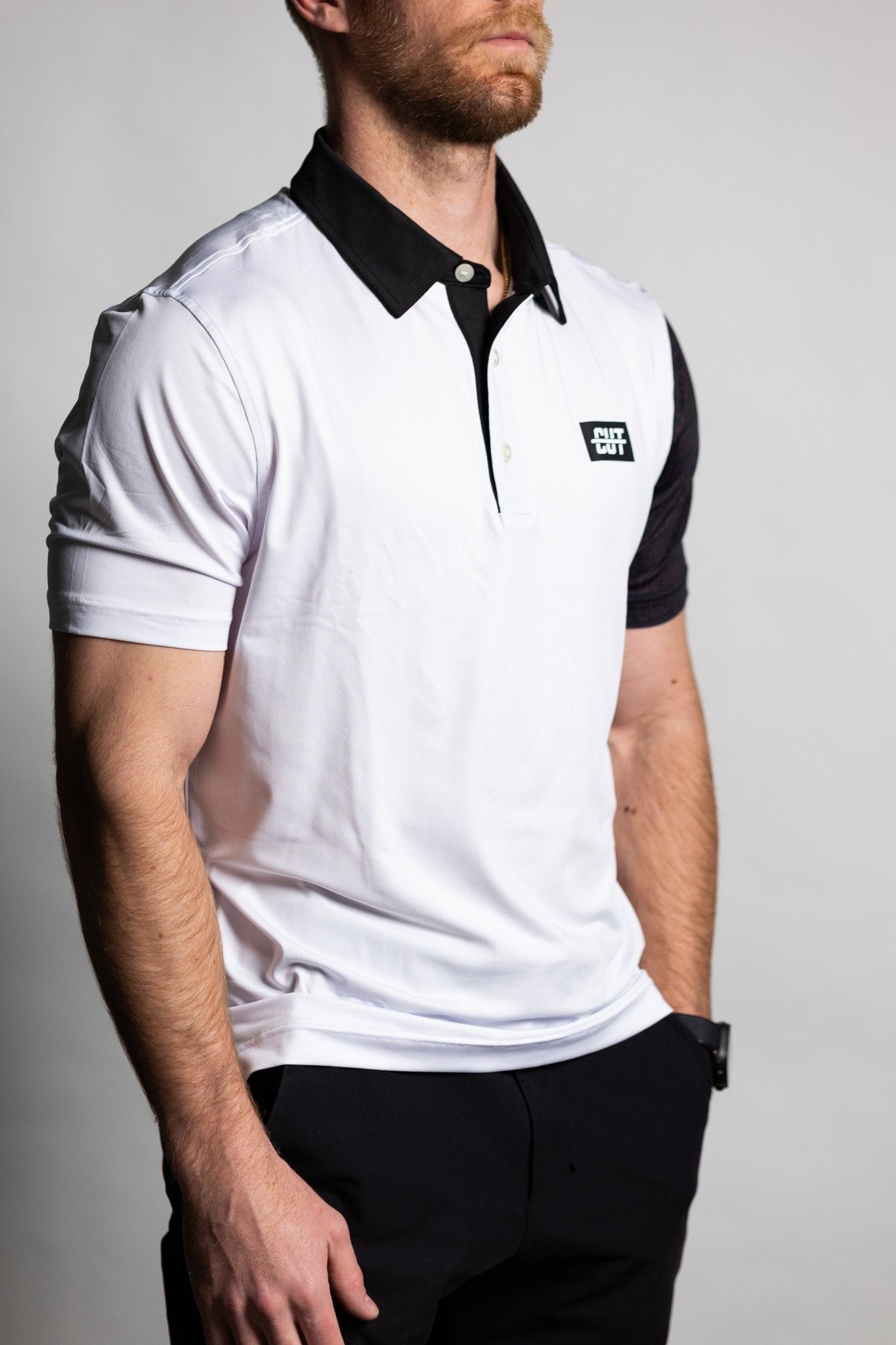 Man wearing GOLF Arm Whiteout Polo with contrasting black collar and detailed sleeve design in golf apparel style