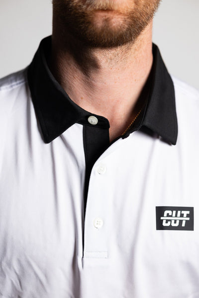 Close-up of a man wearing a GOLF Arm Whiteout Polo with a black collar and white fabric featuring a Cutline Golf Goods logo.