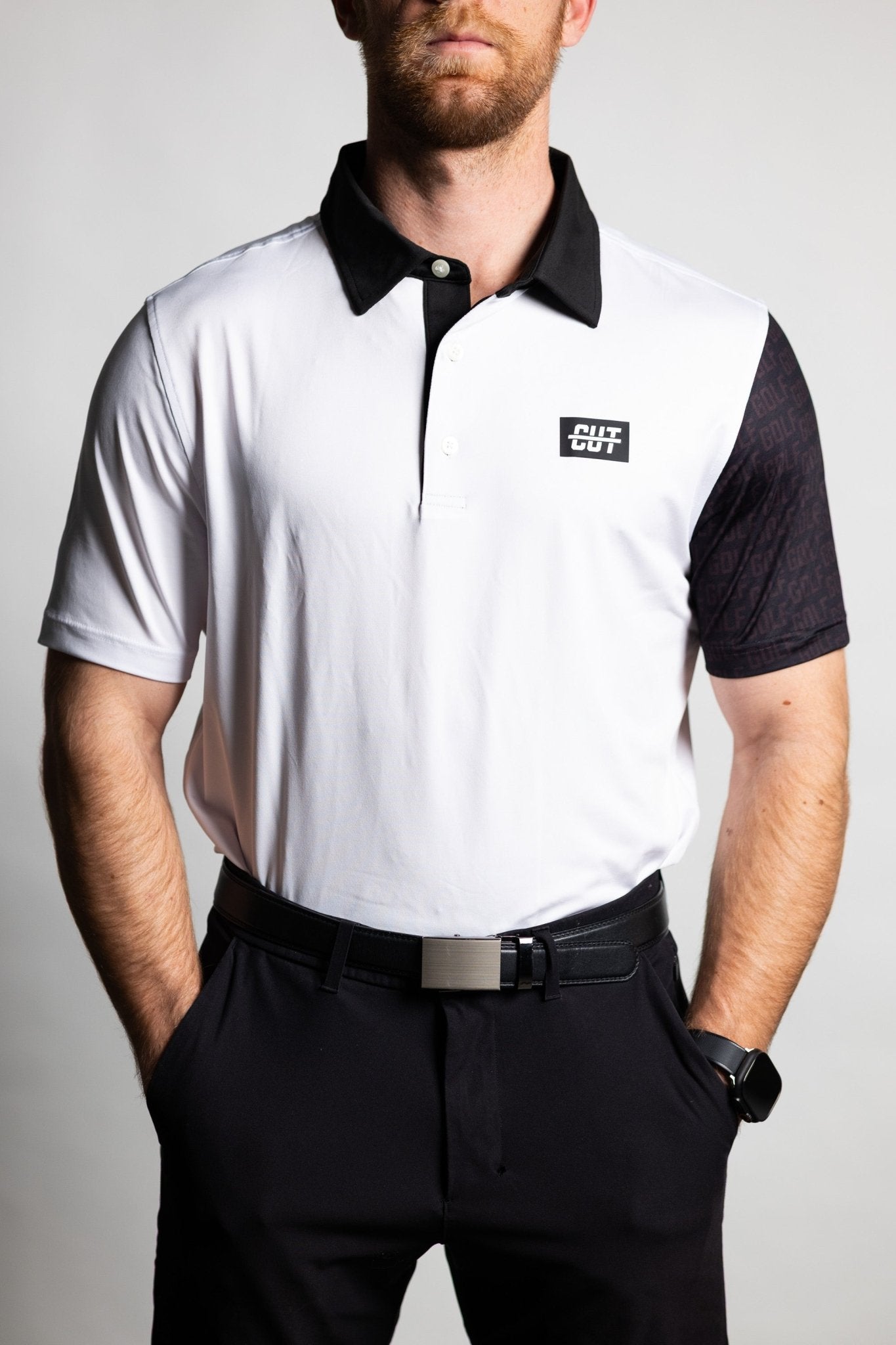 Man wearing GOLF Arm Whiteout Polo with black collar and right sleeve, paired with black pants and belt.