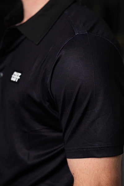 Close-up of a black polo sleeve featuring subtle pattern and logo on Deep Topo Black Polo golf apparel