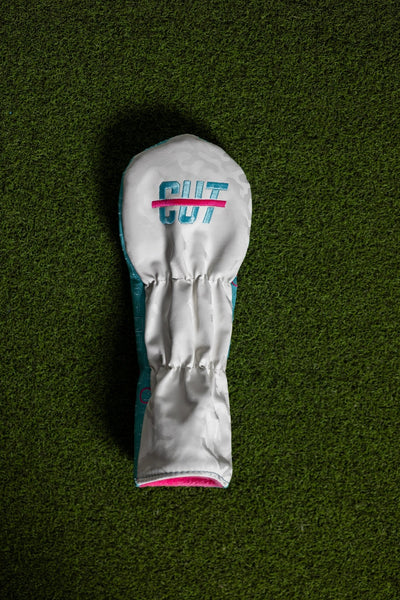 Scorecard Teal Fairway Cover with teal and white design and pink accents lying on green grass background