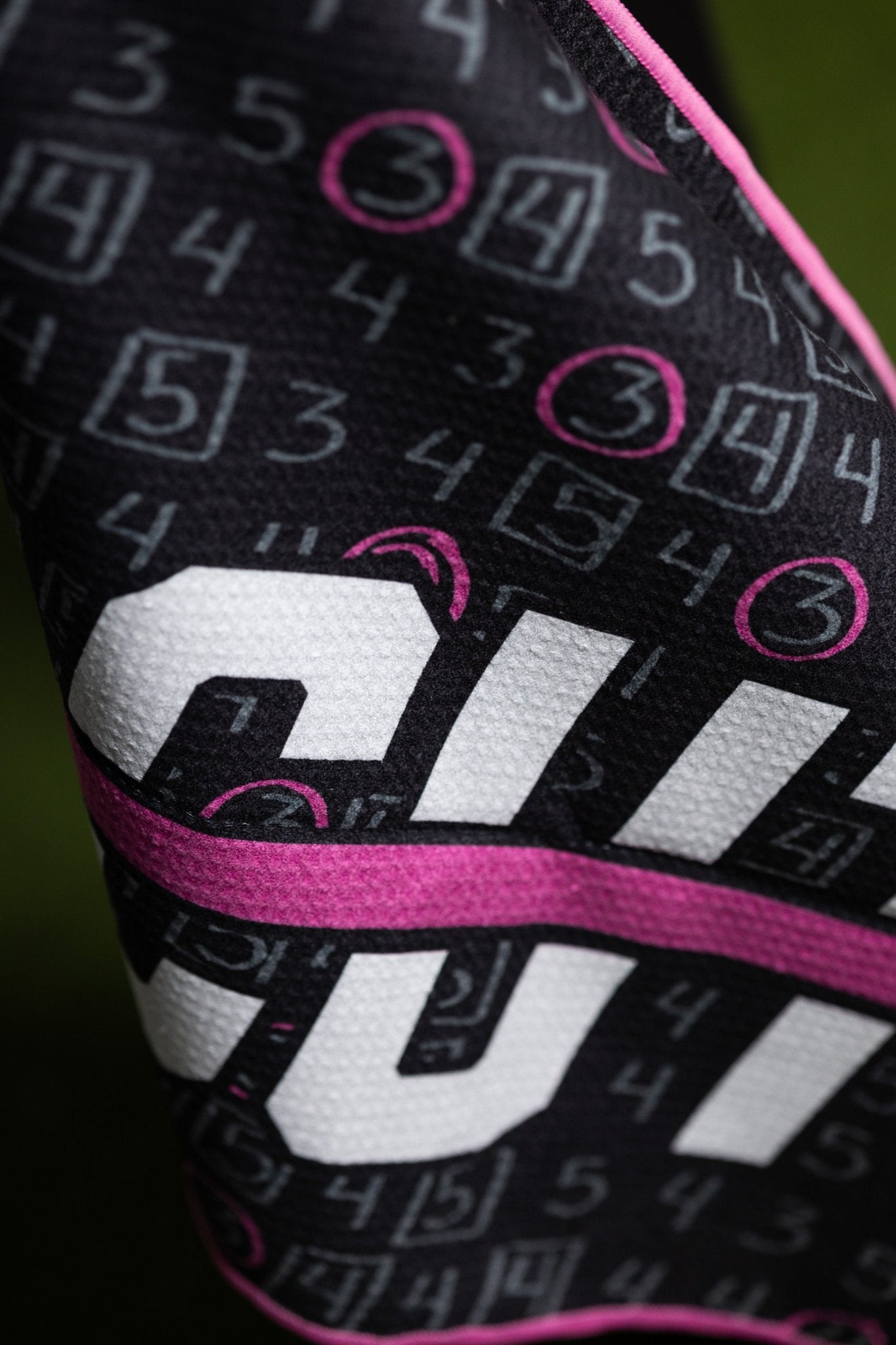 Close-up of Pink Scorecard Oversized Towel showing black fabric with pink and white golf scorecard design details