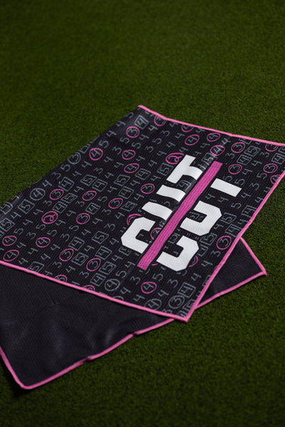 Pink Scorecard Oversized Towel with black background, pink edges, and golf scorecard design on green grass.