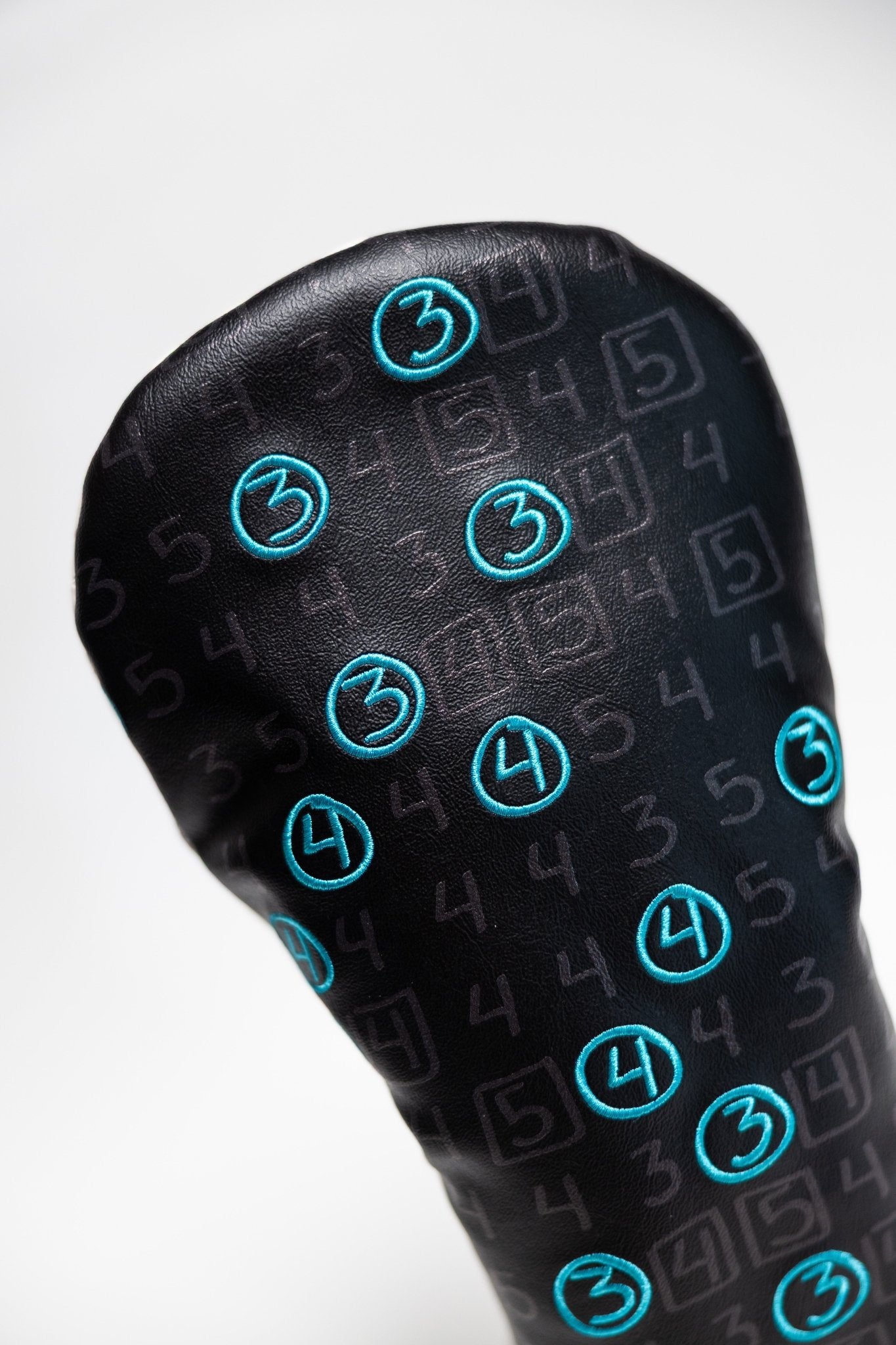 Teal Gator Scorecard Driver Cover with black background and teal embroidered golf score numbers pattern.