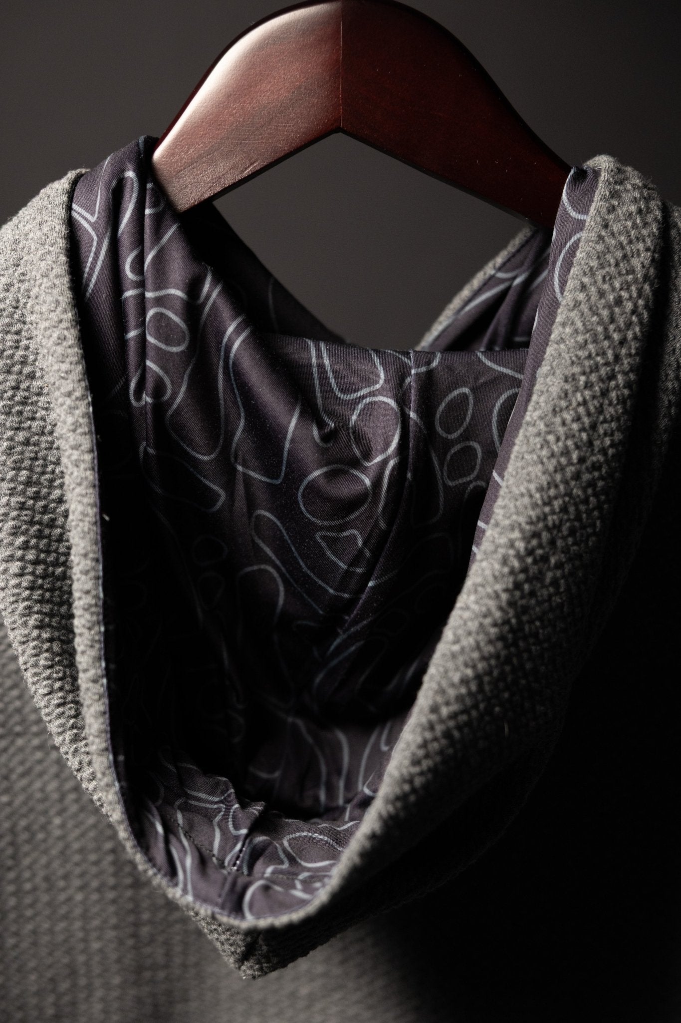 Close-up of the hood interior and textured fabric of the Waffle Knit Cobalt Grey GOLF Hoodie hanging on a wooden hanger