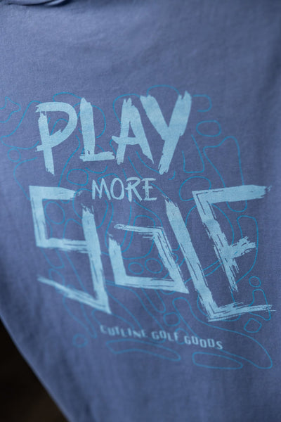 Close-up of blue Play More Golf T-Shirt with artistic text and subtle golf-themed graphic design on soft fabric