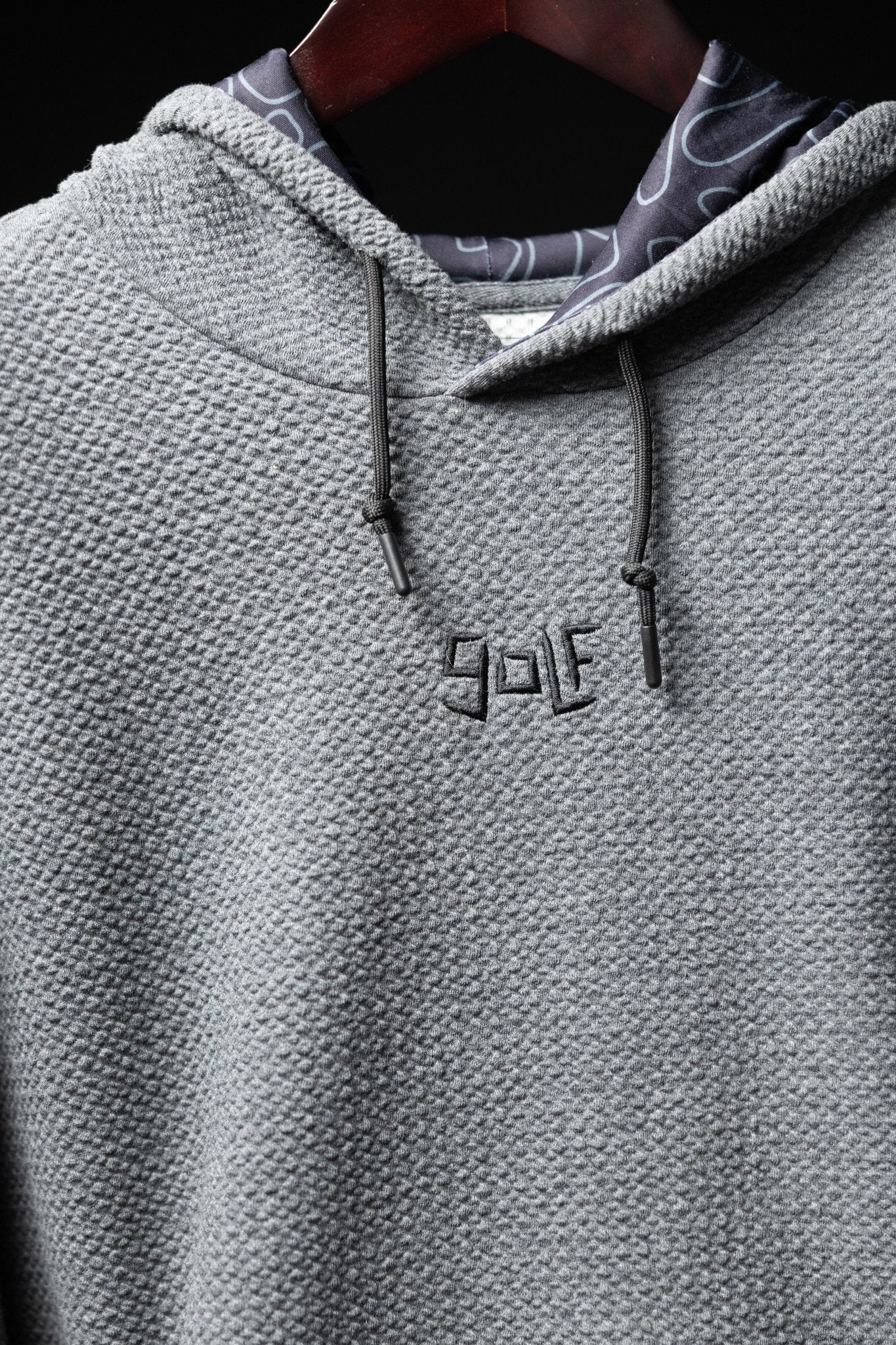 Close-up of Waffle Knit Cobalt Grey GOLF Hoodie showing textured knit fabric and embroidered GOLF logo on chest