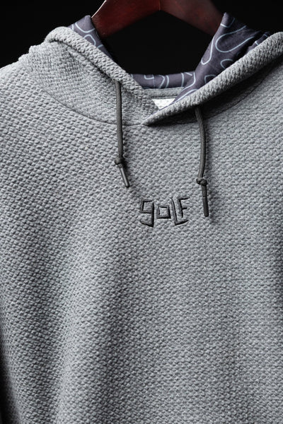 Close-up of Waffle Knit Cobalt Grey GOLF Hoodie showing textured knit fabric and embroidered GOLF logo on chest