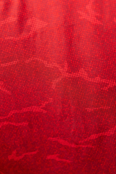 Close-up texture of True Red Tech Camo Polo fabric showcasing red digital camo pattern for golf apparel.